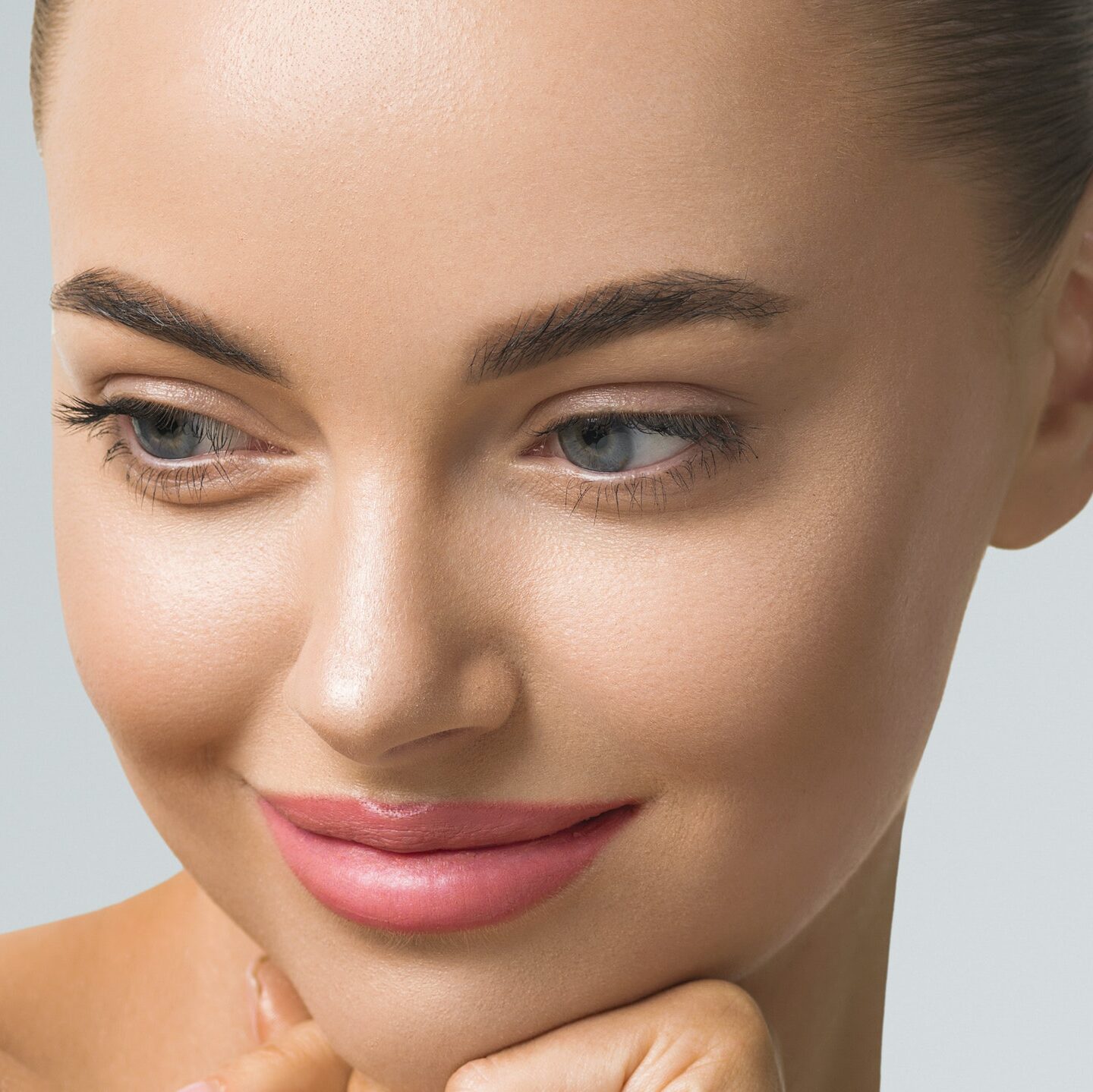 Clean skin woman face close up skin beauty tanned face beautiful smile over blue background