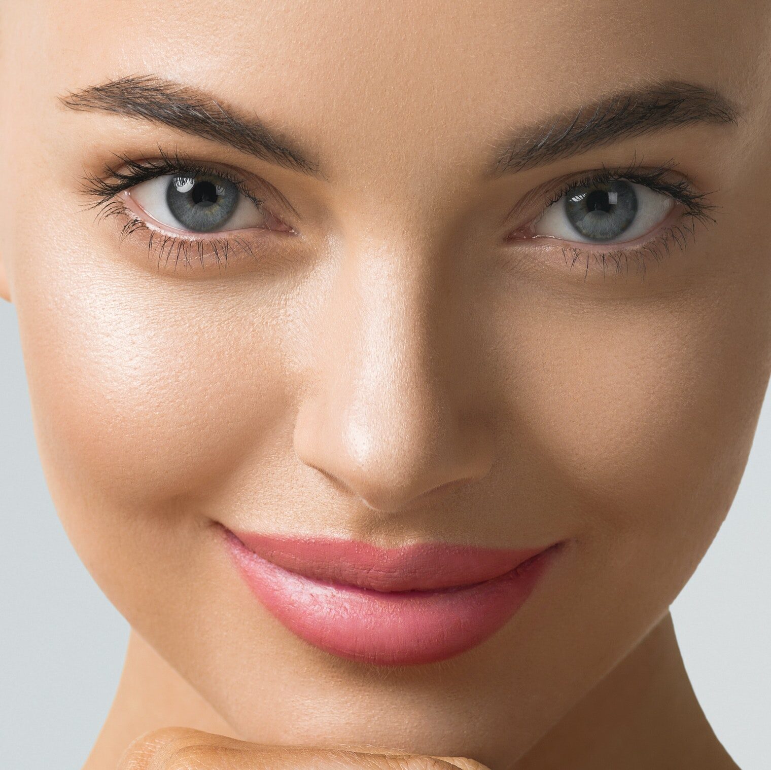 Clean skin woman face close up skin beauty tanned face beautiful smile over blue background